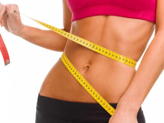 sport, fitness and diet concept - close up of trained belly with